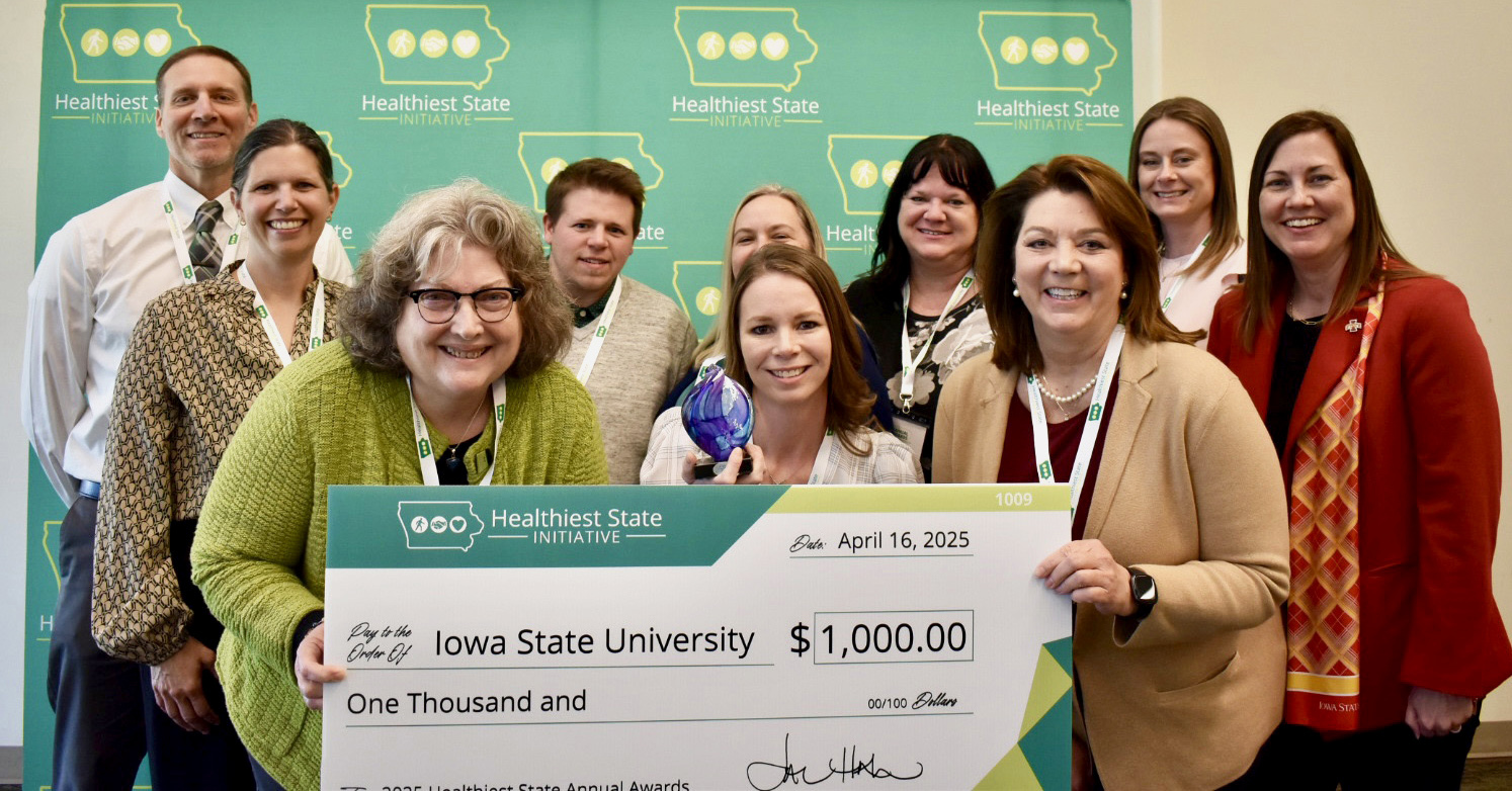 Group of men and women line up with oversized check